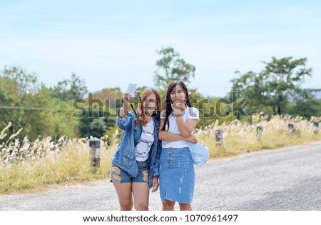 Two young women are taking fun pictures in tourist attractions in Thailand. Concept for Travel. Selective focus.