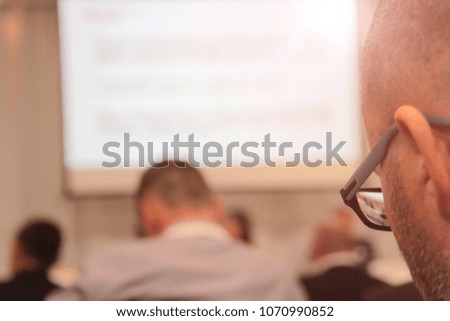Businesspeople during video conference sitting in conference room or hall