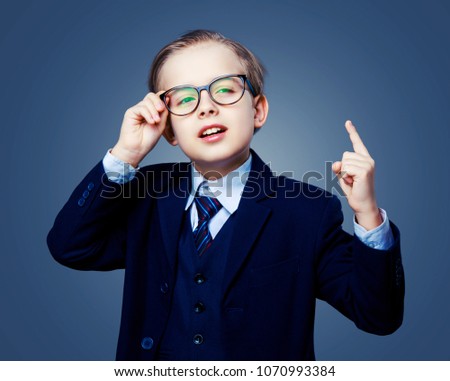 hansome boy wearing glasses and a black suit, isolated against studio background