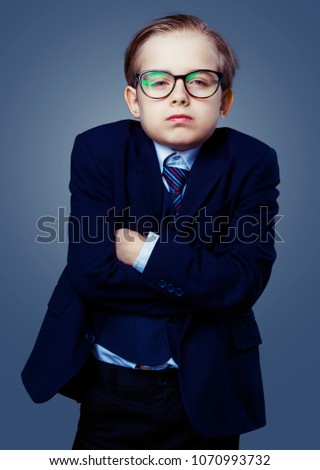 hansome boy wearing glasses and a black suit, isolated against studio background