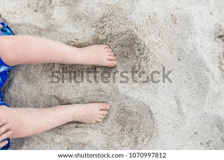 Child legs in the sand from top vacation concept kid playing in the beach little boy barefoot travel holiday design