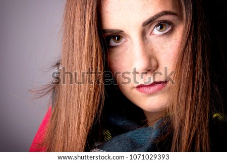 Beautiful young woman with green eyes and freckles posing