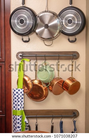 Pots and pans hanging on a kitchen wall to save space