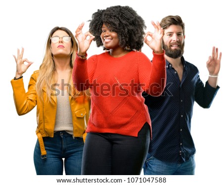 Group of three young men and women doing ok sign gesture with both hands expressing meditation and relaxation