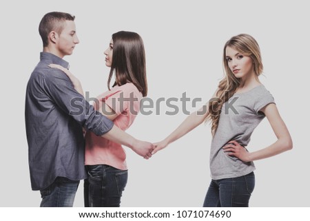 Love triangle. While the guy hugs a girl, he holds the hand of another. isolated on white background.