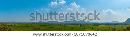 Panoramic view of green field, mountain  and blue sky, agricultural cereal crop, Kanjanaburi, Thailand