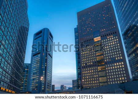 High-rise office building group at dusk of Tokyo . Even after 6 p.m. the lights of many offices remain on