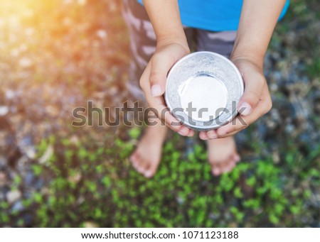 Asian street beggar child holding a cup asking for help and charity 