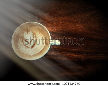 Coffee latte art on a wooden table with sunlight