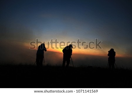 Silhouette of a photographer on sunrise background
