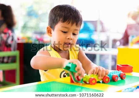 A cute child playing with color toy indoor Royalty-Free Stock Photo #1071160622