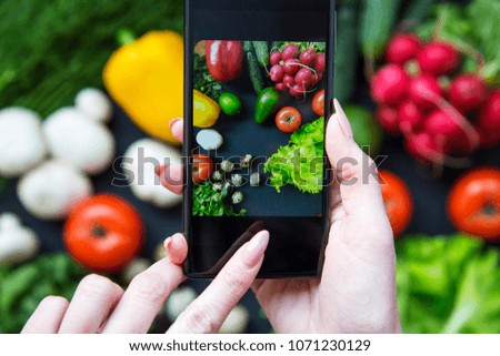 Girl taking picture of healthy food with her smartphone. Vegan food concept. Top view.