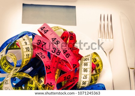 scales and metric tapes with steel cutlery. diet and slimming concept