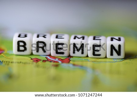 Word BREMEN formed by alphabet blocks on atlas map