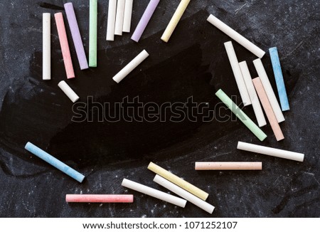 Row of Multicolored Chalks Crayons on Dark Blackboard Background. Business Creativity Graphic Design Crafts Kids Back to School Concept. Copy Space