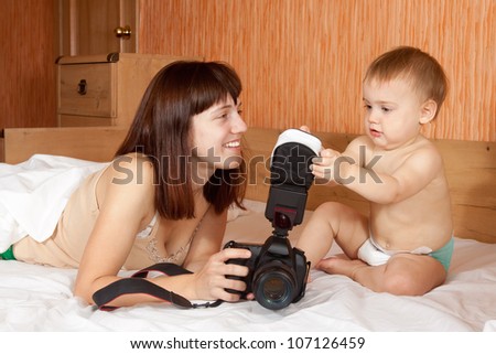Happy mother with baby takes photo in home