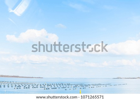 Scene seascape non focus with blue sky and white clouds  with sea or ocean view and some black object ,beautiful nature in europe, spring season in sunny day, the weather is good and air very fresh.