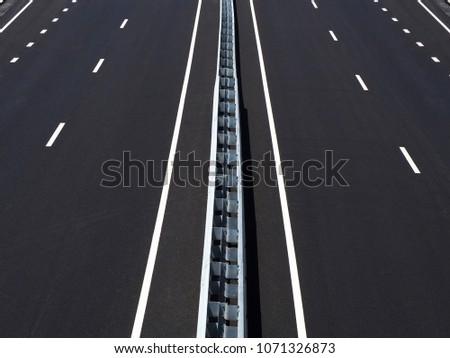 Asphalted highway. Empty motorway. High-speed road of the city. Barrier, guarding rail. Perspective, convergence, top view. Black roadside background