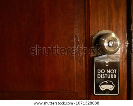 Not disturb sign hanging on the wooden door 