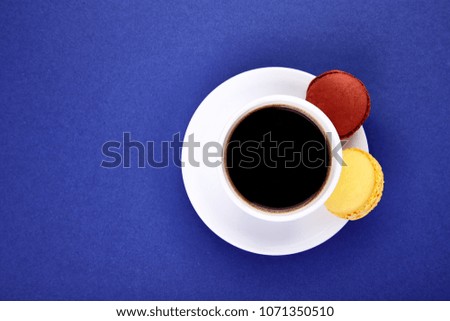 Sweet Dessert Macaron or macaroon with coffee on yellow background, colorful almond cookies, cakes. Good morning, breakfast. Spring. Flat lay. Copy space. Minimalism