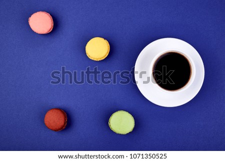 Sweet Dessert Macaron or macaroon with coffee on yellow background, colorful almond cookies, cakes. Good morning, breakfast. Spring. Flat lay. Copy space. Minimalism