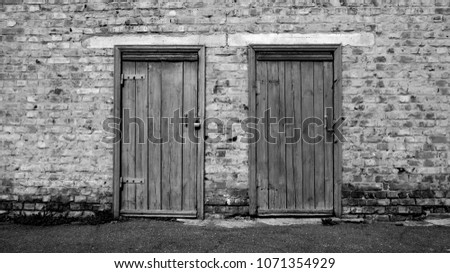 two old wooden doors on a brick building. Black & White Photo