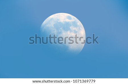 Close up of moon in the morning time with blue sky background, clear morning sky with bright growing moon