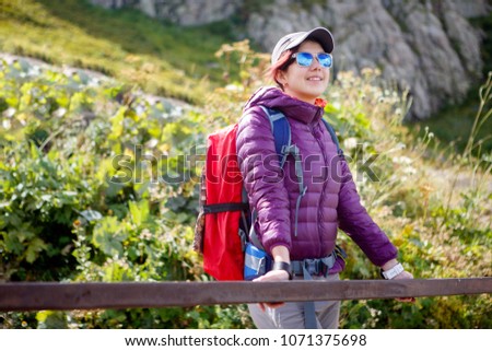 Tourist girl in sunglasses against of mountains