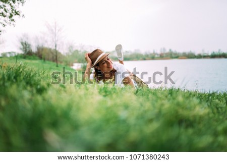 Friendly-looking young woman laying on the grass and enjoying life.