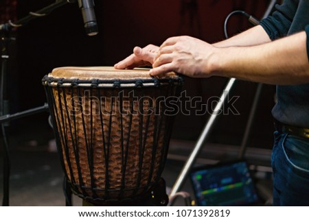African drum, microphone studio recording, drummer beats the drum with his hands movement