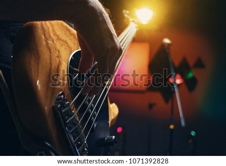bass guitar in the hands of a musician, concept concert, learning to play the guitar, hands of a guitarist close-up