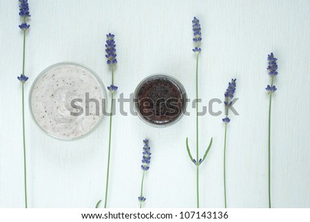 blue lavender flowers and natural cosmetic creams on bright textile background, above view