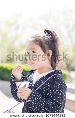 Lovely young asian girls eat ice cream in the outdoors