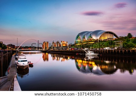 Newcastle upon Tyne, UK. Famous Millennium bridge at sunset. Illuminated landmarks with river Tyne in Newcastle, UK and colorful sky Royalty-Free Stock Photo #1071450758
