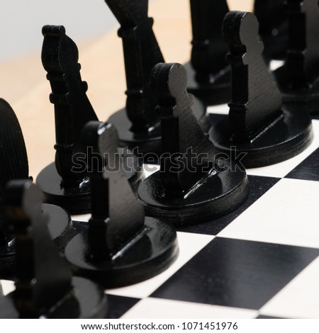 Two chess teams one in front of other on the chessboard. Isolated over white background