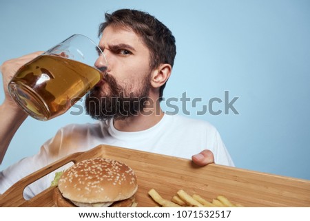 man drinks beer, fast food                               