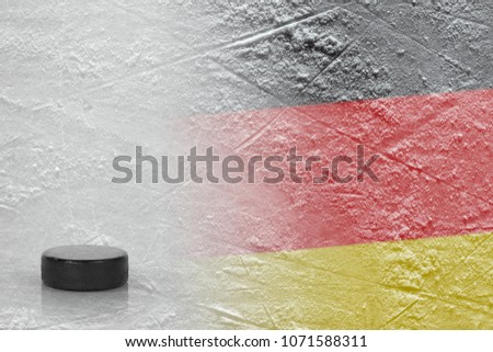 Hockey puck and the image of the German flag on the ice. Concept, hockey
