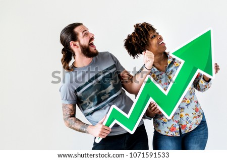 Happy smiling interracial couple holding a growth arrow