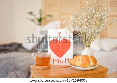 Mother's Morning breakfast on wooden tray near bed with greeting card I love you mom. Mother's Day concept.