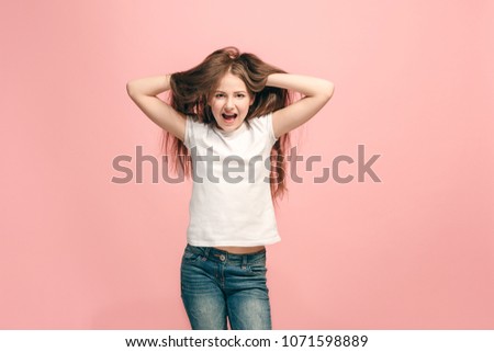 I lost my mind. The teen girl with weird expression. Beautiful female half-length portrait isolated on pink studio backgroud. The crazy teenager. The human emotions, facial expression concept.