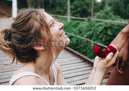 Woman proposing to her happy girlfriend outdoors love and marriage concept Royalty-Free Stock Photo #1071606053