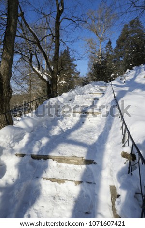 Stone staircase under the snow. Dangerous ice on the sidewalks in the city.