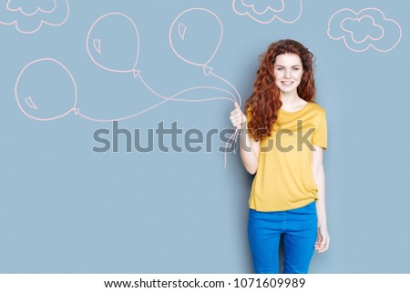 Holiday mood. Positive young babysitter getting ready for a Birthday party and holding beautiful balloons Royalty-Free Stock Photo #1071609989