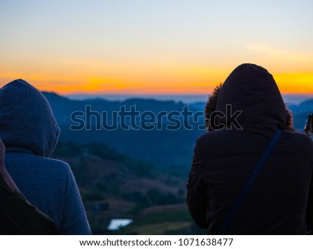 travel and photographer concept from backside of woman with hoodie cloth stand and see mountain view and sunrise