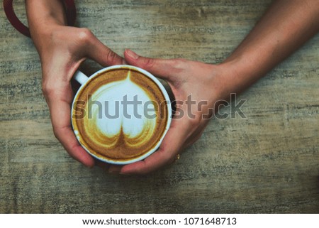 Woman hand catch coffee mug Heart-shaped bubble. Dark style