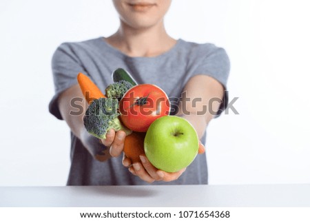 close-up view of woman holding fresh ripe apple and vegetables