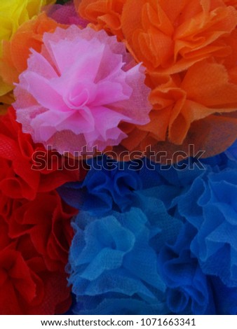alms flowers , Colorful ribbon flowers and coins folding with mulberry paper for giving alms to make merit in Thai's religious traditional. It is a beautiful picture. Use for colorful background.

