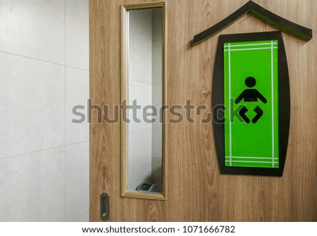 Baby Symbol on green wooden background at toilet.