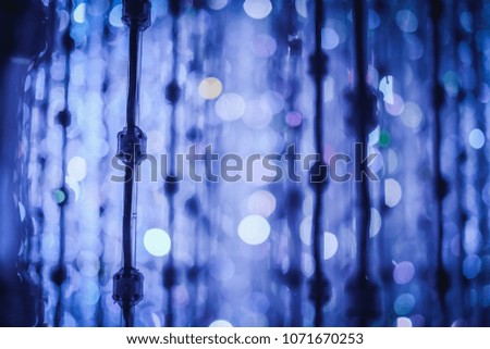 an defocused abstract image of the circular bokeh source from blue color LED lights setting wire in the dark place at the festival 