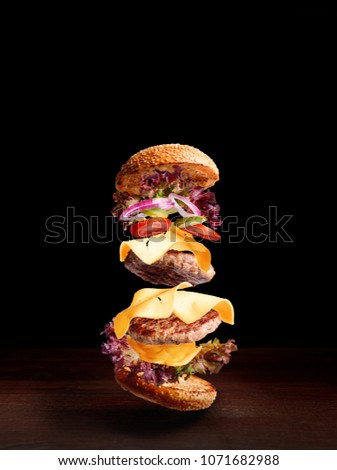 double cheeseburger on a wooden surface with a dark background and space for text